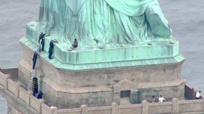 protes-kebijakan-pemerintah-amerika-perempuan-ini-panjat-patung-liberty_20180705_100749