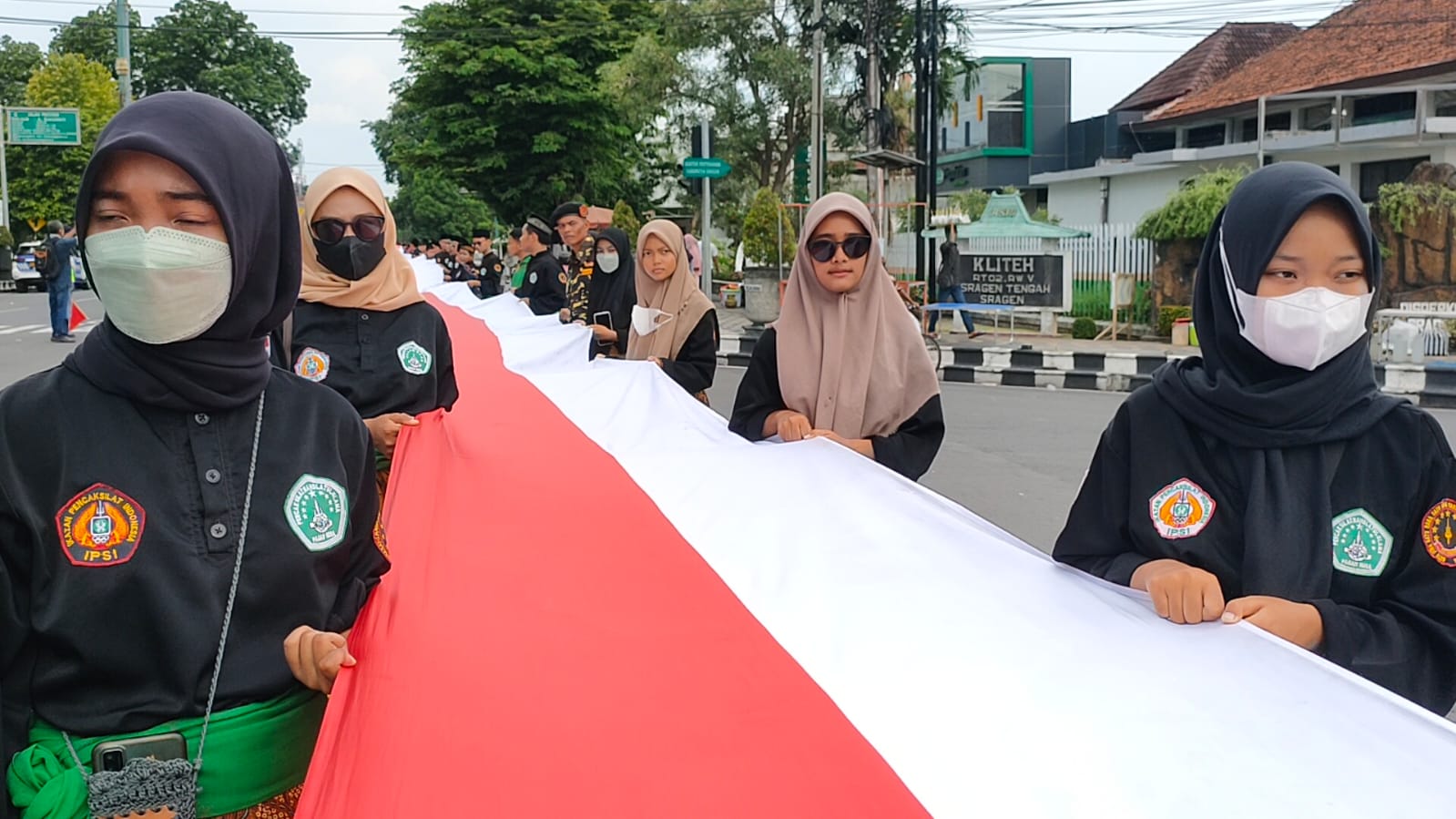 Para santri saat membentangkan bendera merah putih raksasa sepanjang 1.000 meter atau 1 kilometer dalam rangka memeriahkan Hari Santri Nasional dari GOR Diponegoro ke Alun-alun Sragen, Jumat (4/11/2022). Foto/Wardoyo