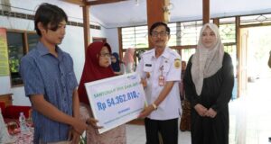 Wakil Bupati Sragen Suroto didampingi Kepala BPJS Ketenagakerjaan Cabang Sragen Amalia Ayuni menyerahkan santunan jaminan sosial kepada ahli waris perangkat desa di Kabupaten Sragen. Penyerahan santunan tersebut dilakukan secara simbolis di Aula Balai Desa Toyogo, Kecamatan Sambungmacan, Rabu (10/1/2024) || Foto Pemkab Sragen